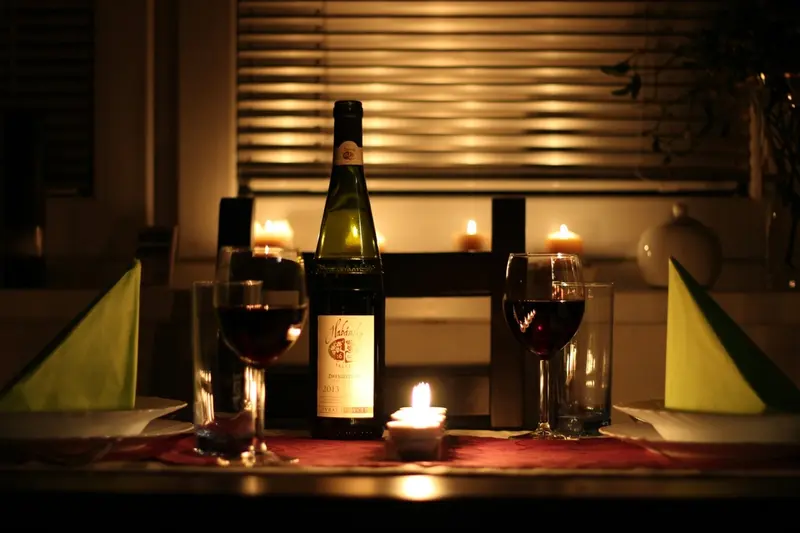 Vinflaska och glas i levande ljus