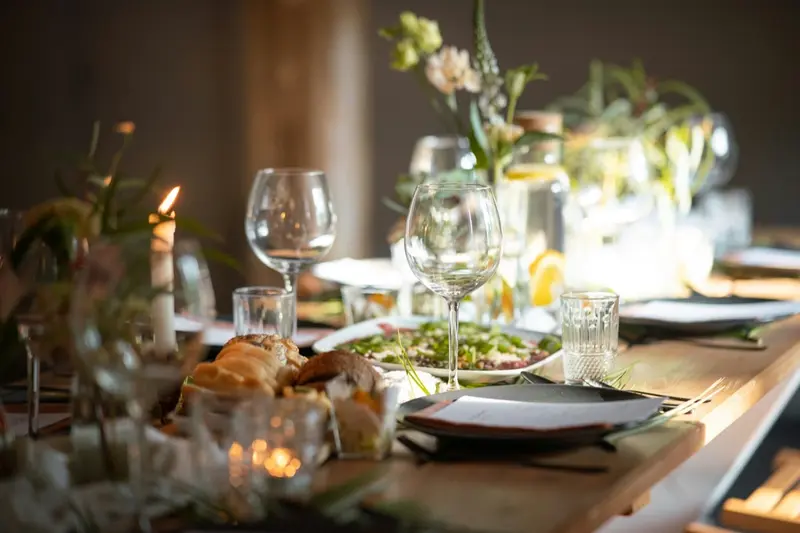 Elegant dukning med vinglas, ljus och blommor